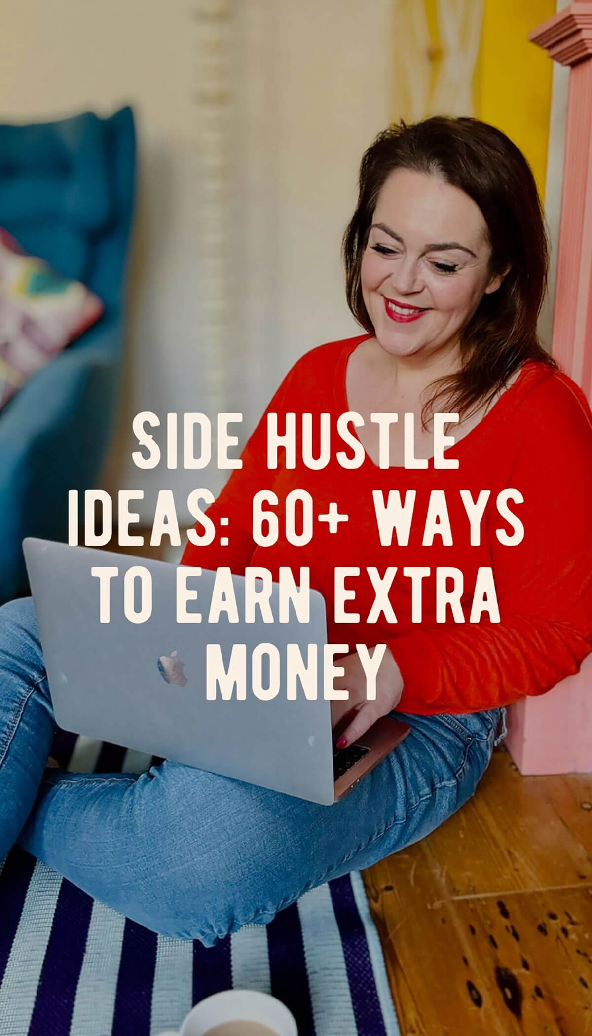 Woman in red jumper sitting cross-legged on striped rug working on laptop by pink fireplace, with text overlay reading Side Hustle Ideas: 60+ Ways to Earn Extra Money, perfect for women looking to earn extra income