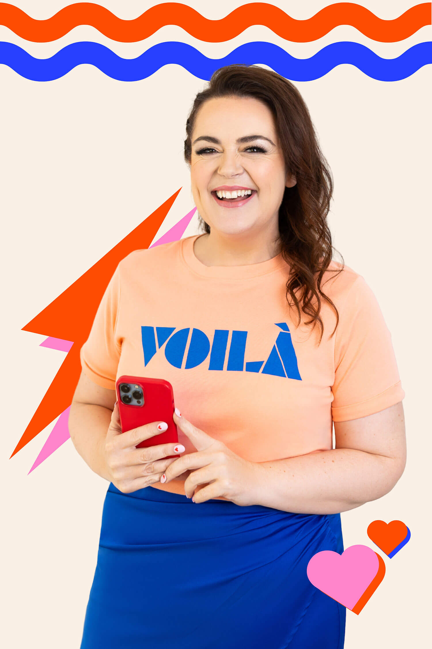 A smiling woman holding a red phone against a bright graphic backdrop, wearing a peach “Voilà” T-shirt and blue skirt in a fun, colourful branding portrait for the small business blog.