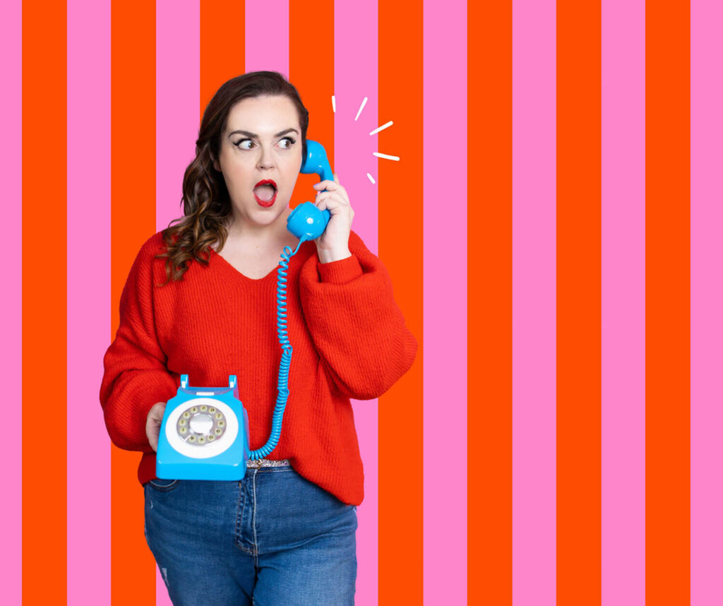 rosie parsons holds a blue vintage phone and looks shocked!