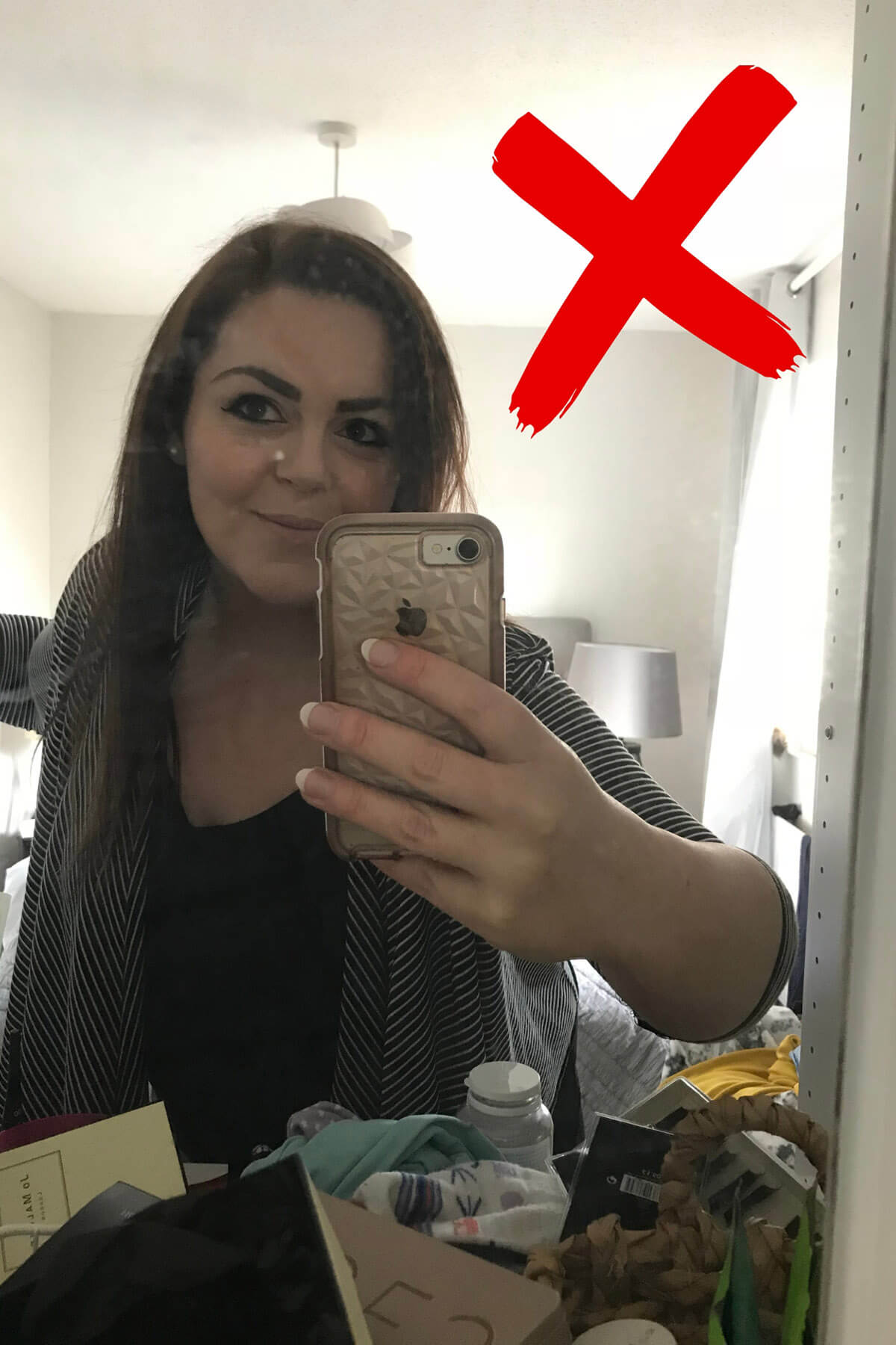 Example of mirror selfie with distracting cluttered background marked with red X, showing messy bedroom with clothes, bottles and random items visible in reflection – demonstrating why background matters in self portraits